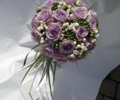 Allestimento floreale rotondo con rose lilla