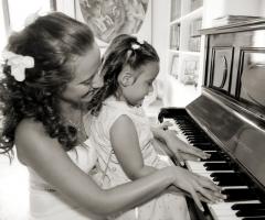 Foto della sposa che suona il piano con la damigella