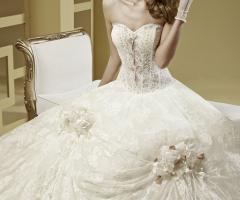 Abito da sposa con bustino stretto e fiori applicati sulla gonna