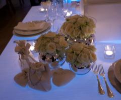 Sacchetti porta confetti per il matrimonio e vasi con rose bianche