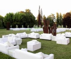 Allestimento di divanetti bianchi nel parco della villa