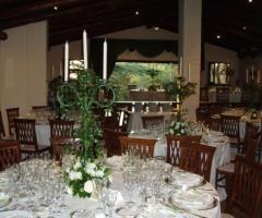 Alzata di fiori bianchi e piante per i tavoli delle nozze