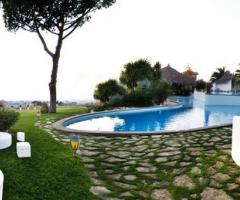 Allestimento della piscina con divanetti bianchi