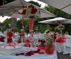 Allestimento con rose rosse per i tavoli di nozze