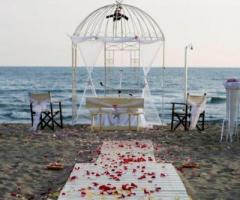 Allestimento della cerimonia in spiaggia con gazebo a forma di gabbia