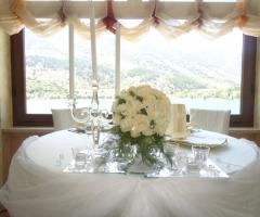Il tavolo degli sposi allestito con rose bianche e candelabro