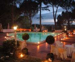 Piscina della location di matrimonio illuminata dalle fiaccole