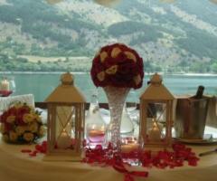 Allestimento con alzate di fiori e lanterne