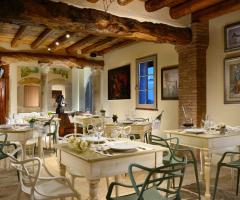 La sala principale della Tenuta:  luci, legni antichi, pietra rosa, quadri rendono unica l'atmosfera