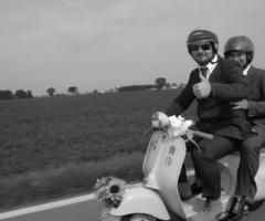 Foto dello sposo e del testimone di nozze in vespa