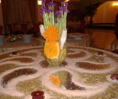 Allestimento del tavolo di nozze con frutta, verdura e fiori