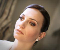 Capelli raccolti di lato e make up sui toni del bronzo