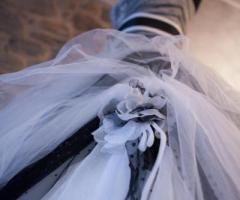 Elaborato abito da sposa con giochi di veli, ricami e tulle dai colori scuri