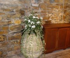 Addobbo floreale con santini bianchi e verde decorativo