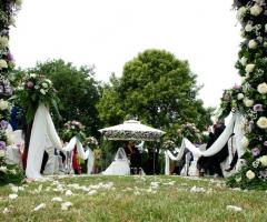 Allestimento della cerimonia in giardino con rose bianche e lilla
