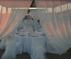 Tavoli total white allestiti sulla spiaggia