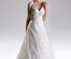 Abito da sposa dalla linea semplice, ricoperto da un importante velo ricamato