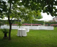 Allestimento tavoli per l'aperitivo di matrimonio in giardino