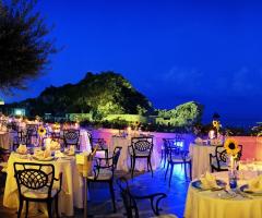 Tavoli allestiti per il ricevimento di matrimonio in terrazza sul mare