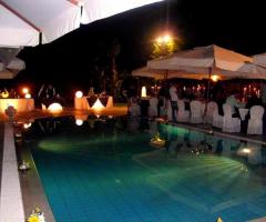 Allestimento tavoli per ricevimento di matrimonio a bordo piscina presso Villa Nettuno