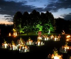 Ricevimento di nozze in giardino di sera con tavoli illuminati