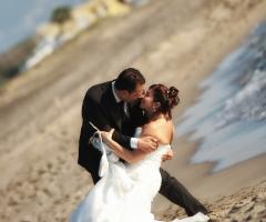 Foto del bacio degli sposi in riva al mare