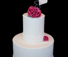 Torta di matrimonio multipiano con dettagli di fiori rosa e cuori