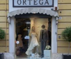 Pregiati abiti da sposa e da sposo esposti nella vetrina dell'Atelier Ortega Sposi