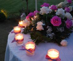 Allestimento con candele e rose per il tavolo della torta nuziale
