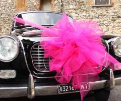 Foto della macchina da cerimonia allestita con fiocco rosa