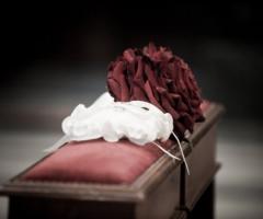 Foto del particolare del bouquet della sposa e del cuscino porta fedi nuziali