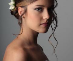 Acconciatura raccolta con boccoli che scendono da un lato