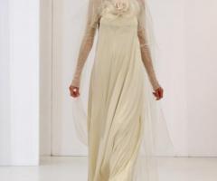 Abito da sposa con grande fiore sul petto e maniche lunghe