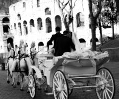 Gli sposi in carrozza trainata da una quadriglia di cavalli bianchi
