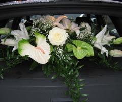 Cappelliera dietro di un'auto degli sposi con anthurium e lilium