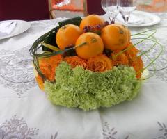 Composizione di arance e fiori per i tavoli di nozze