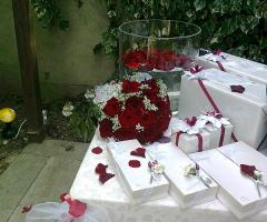 Il tavolo delle bomboniere con rose rosse
