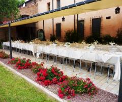 Tavoli sotto la veranda per un matrimonio all'aperto