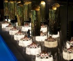 Tavoli rotondi sotto illuminati per il matrimonio a bordo piscina