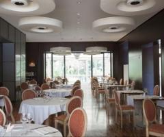 La sala con tavoli del NH Hoteles Palermo