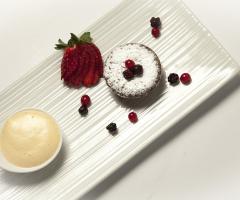 Tortino di cioccolato su crema di zabaione con frutti di bosco