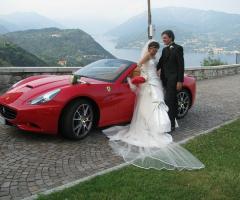 Gli sposi posano vicino alla macchina da cerimonia