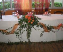 Allestimento floreale in arancio dei tavoli per il matrimonio