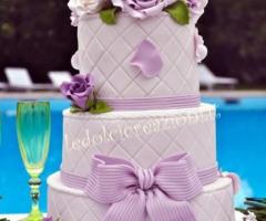 Torta nuziale con fiori lilla e fiocco