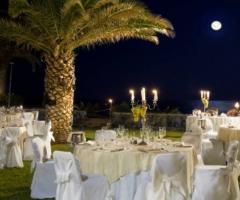 Allestimento dei tavoli per il ricevimento di nozze nel giardino tropicale dell'hotel