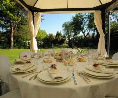 Tavolo allestito per il ricevimento di nozze con centrotavola e segnaposto