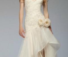Corpetto ricamato e gonna dalle velature elaborate e asimmetriche per un abito da sposa originale e moderno