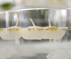 Decorazione con candele galleggianti e perle colore oro