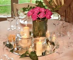 Centrotavola floreale con candele per il ricevimento di nozze