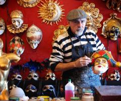 Maestro artigiano mentre prepara una maschera veneziana